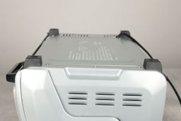 On a grey background, the bottom of the Hamilton Beach 31127D 6-Slice Easy Reach Toaster Oven has four stands and holes.