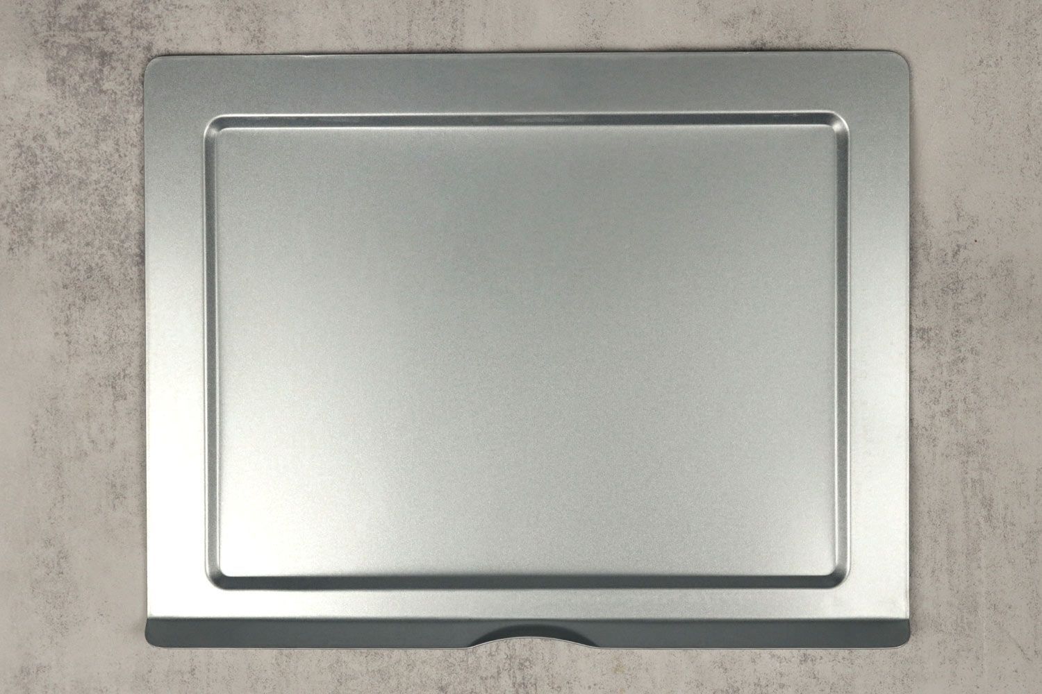 A silver removable crumb tray of the stainless steel Hamilton Beach 31127D Easy Reach Toaster Oven on a grey background.