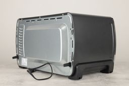 The back and left sides of the Oster TSSTTVMNDG-SHP-2 Large Toaster Oven. The back has a power cord, two buffers, and holes.