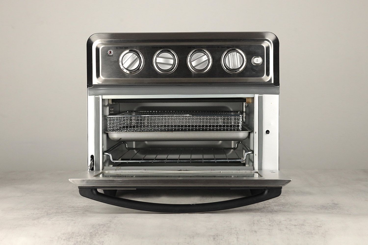 The front of an opened Cuisinart TOA-60 Convection Toaster Oven Air Fryer on a white background. From the bottom up are one baking rack, one baking pan, and an air fryer basket.