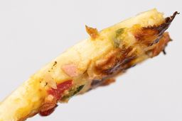 The cross surface of a slice of toast oven baked 9-inch thick-crust meat pizza with cheese, onions, and green bell peppers.