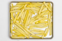 Pieces of baked french fries using the Hamilton Beach 31401 Toaster Oven on a silver baking pan on a white background.