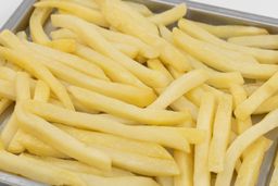 A close-up of pieces of baked french fries using the Black+Decker TO1760SS on a silver baking pan on a white background.