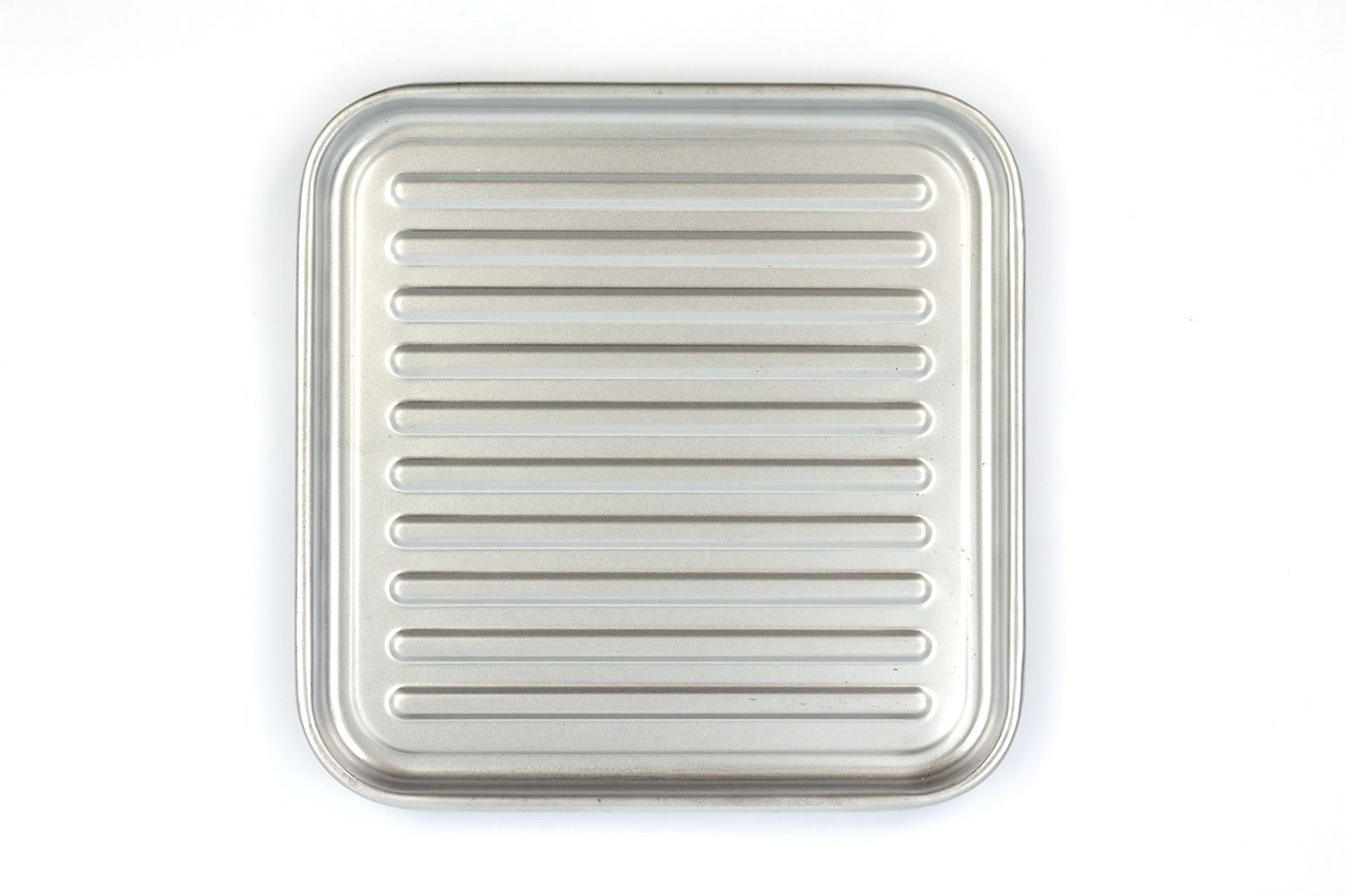 A grooved silver baking pan of the stainless steel Panasonic NB-G110P FlashXpress Compact Toaster Oven on a white background.