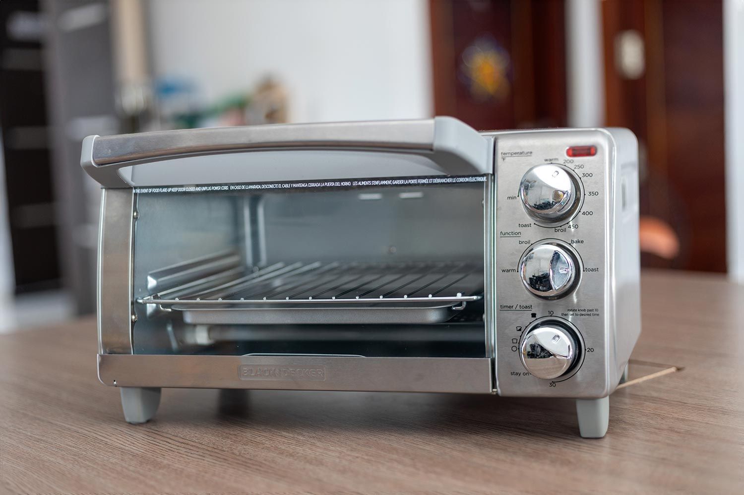 The front of a closed stainless steel Black+Decker TO1760SS 4-Slice Natural Convection Toaster Oven on a white background.