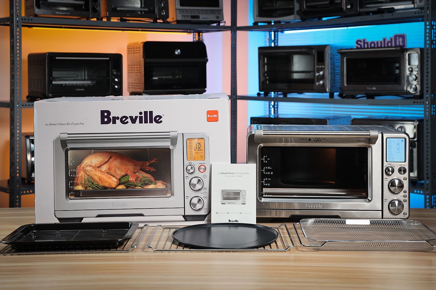 From the bottom left to right is the Breville BOV900BSS Smart Oven Air Fryer Pro, 2 oven racks, a baking pan and broiler rack combo, a pizza pan, and an air fryer basket.