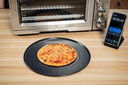 Using a pizza pan to bake a 9-inch thick-crust meat pizza with the Breville BOV900BSS Smart Oven Air Fryer Pro in 5 min.