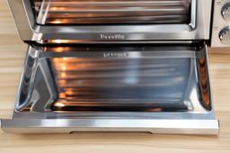 The stainless steel slide-out crumb tray of the Breville BOV900BSS Smart Oven Air Fryer Pro