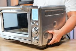Alan from ShouldIt carrying the Breville BOV900BSS Smart Oven Air Fryer Pro by its side handles.