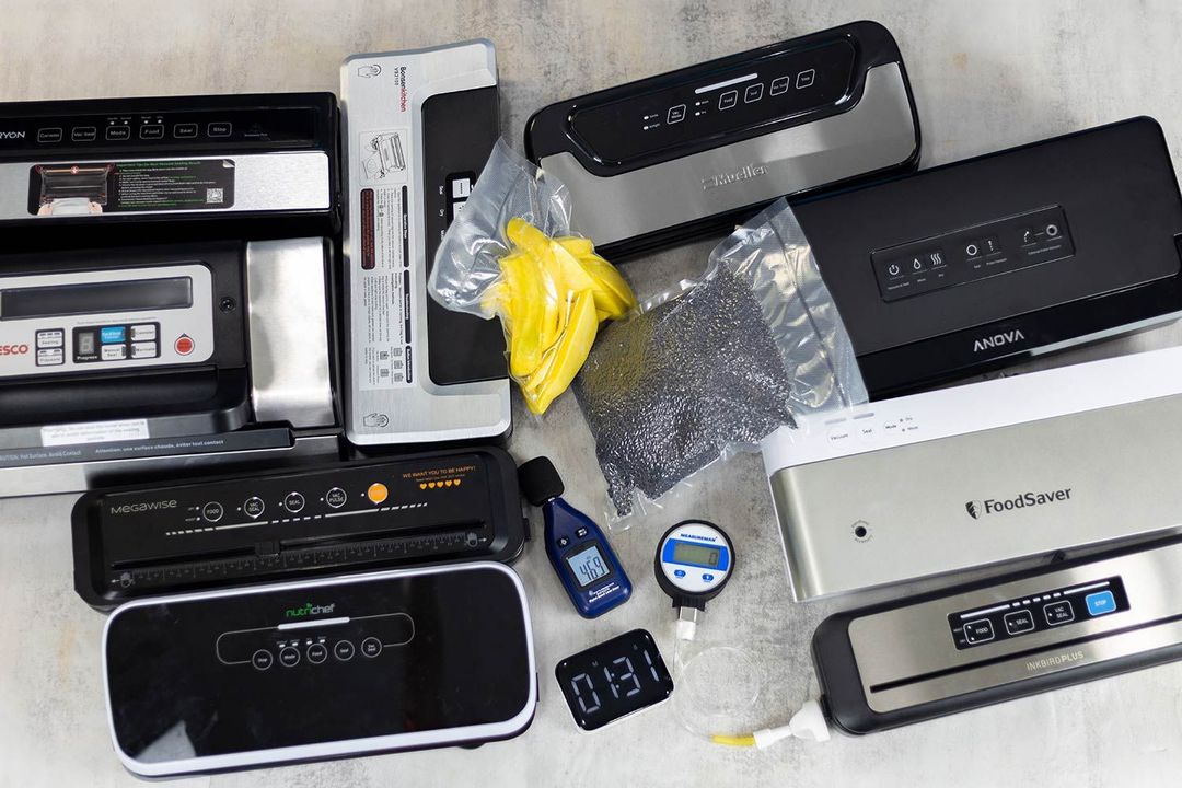 Vacuum sealers we’ve tested in the lab, along with the testing instruments (vacuum gauge, timer, noise level meter) and vacuum-packed bags of fruit slices and grains