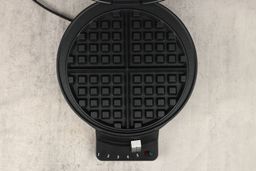 A close-up view of the Cuisinart WMR-CA’s waffle plate. It has classic-style patterning and is coated in black non-stick.