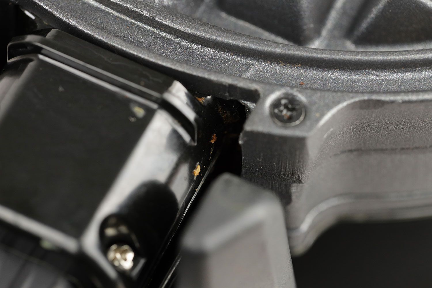 A close-up of dirty gunks and leftover batter within a small nook next to the handle of the Black and Decker WMD200B double Belgian waffle maker.