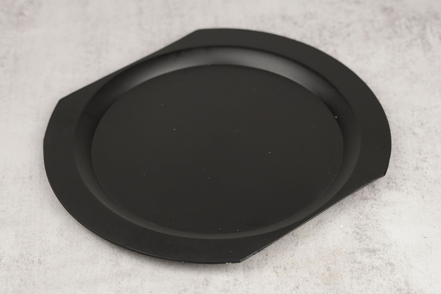 The removable and washable black, plastic drip tray of the Black and Decker double waffle maker WMD200B.