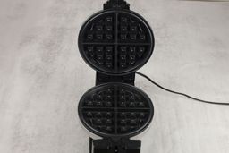 A close-up of one of the Bella 13991’s waffle plates. The plate has a Belgian-style patterning and a black non-stick coating.