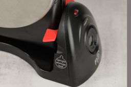 Close-up shot of the red plastic retainer that keeps the baking chamber of the Presto waffle maker aloft when stored upright.