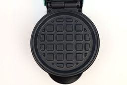 A close-up shot of one of the Nostalgia MWF5AQ’s black, non-stick waffle plates.