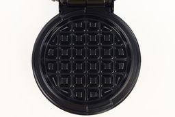 A close-up shot of the Holstein waffle maker’s cooking plate. It is black and treated with a glossy layer of non-stick.