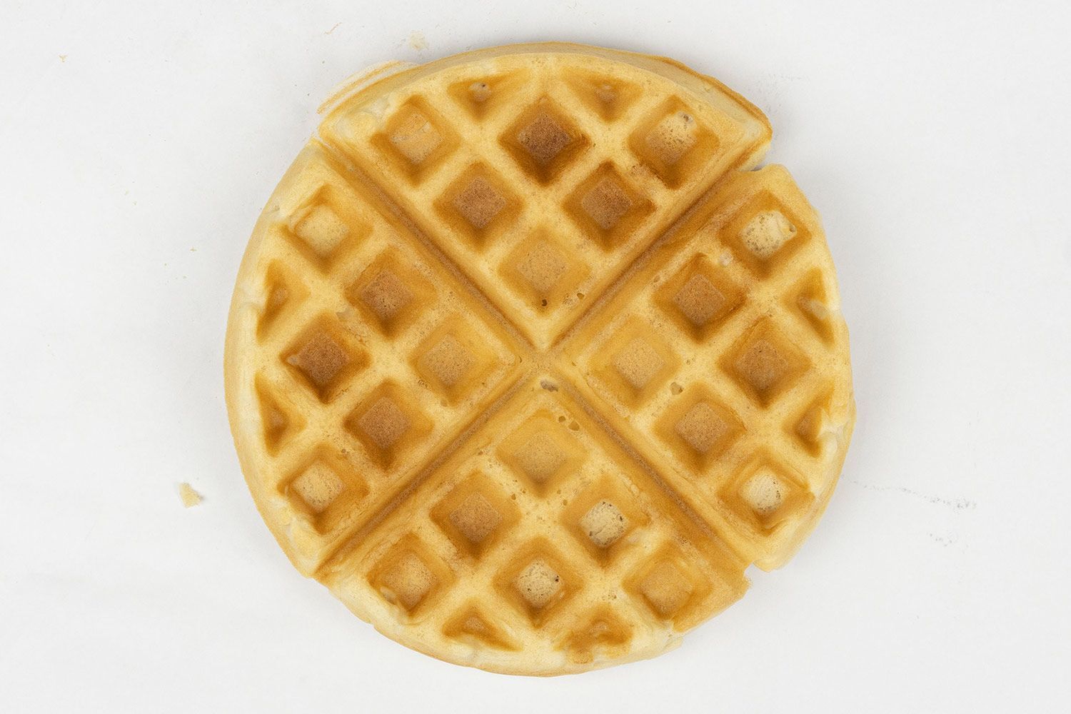 The dark brown top crust of a waffle baked in 7 minutes and 30 seconds.