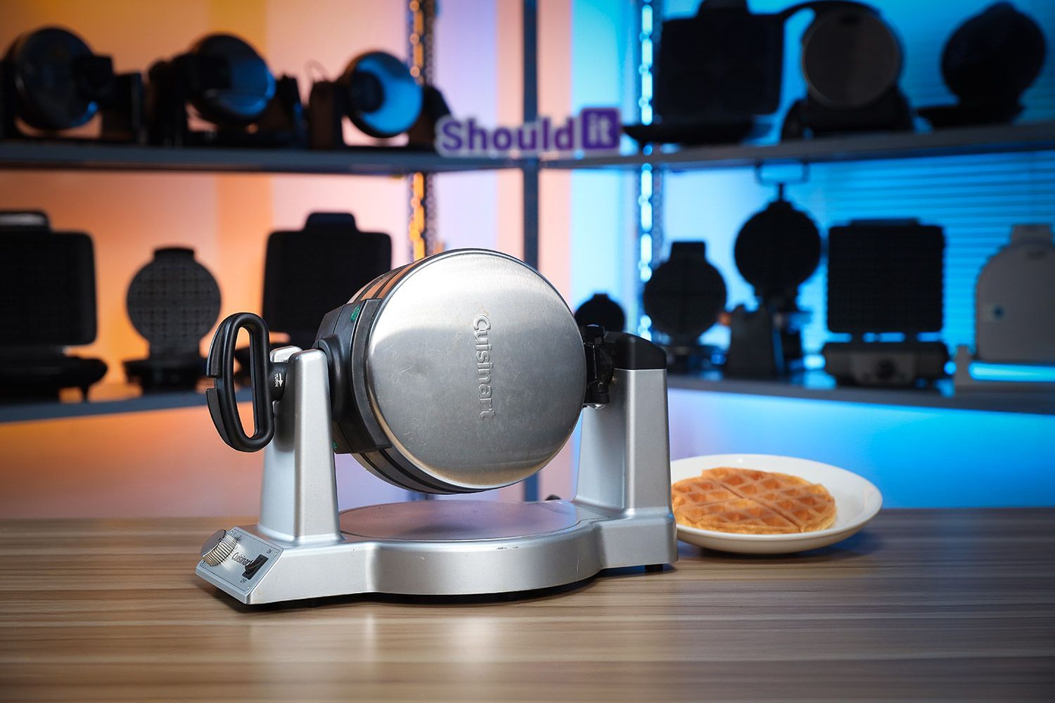 Cuisinart WAF-F20P1 waffle maker on a white countertop next to a plate with a single waffle and a sealed bag of Birch Benders instant waffle mix. 