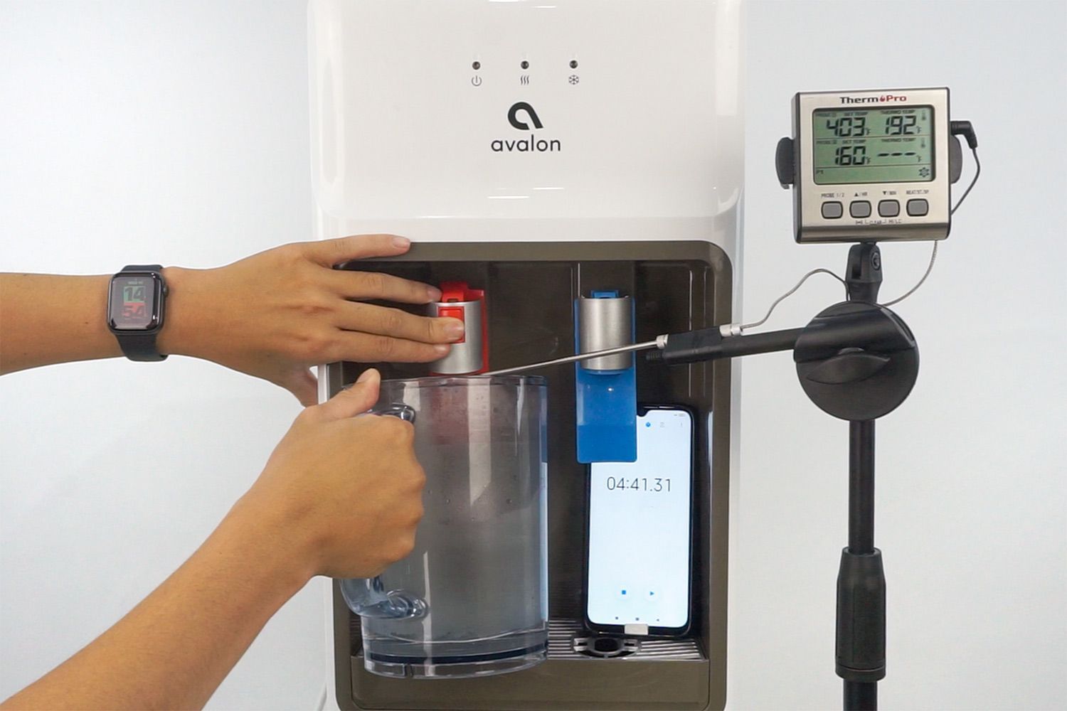 Water temperature being measured as hot water flows out the nozzle of a water cooler dispenser.