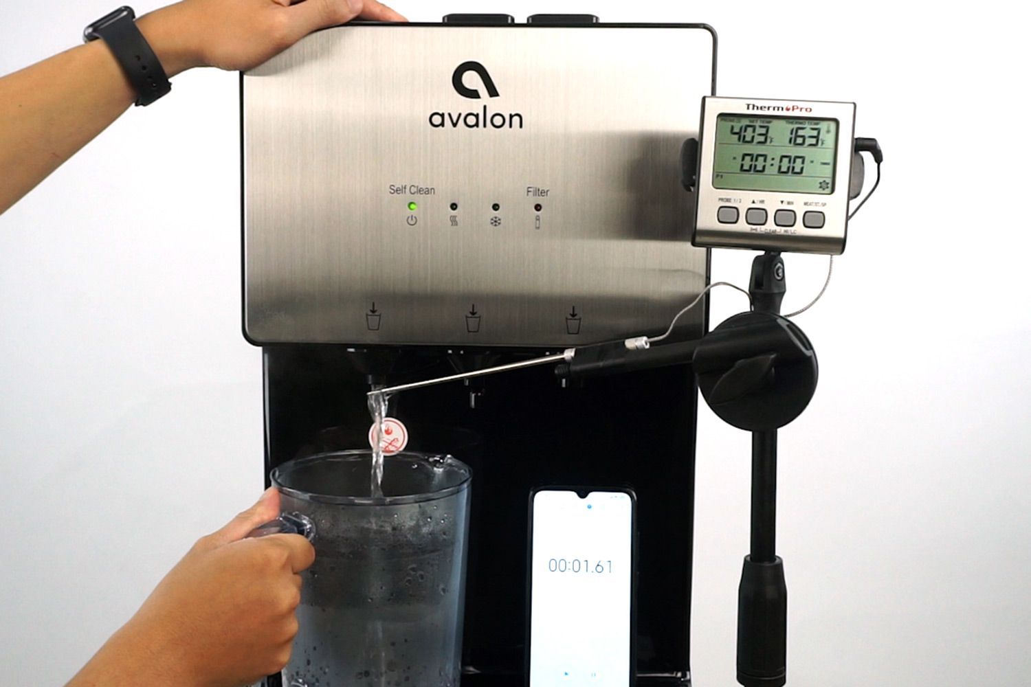 Water temperature being measured as hot water flows out the nozzle of a water cooler dispenser.