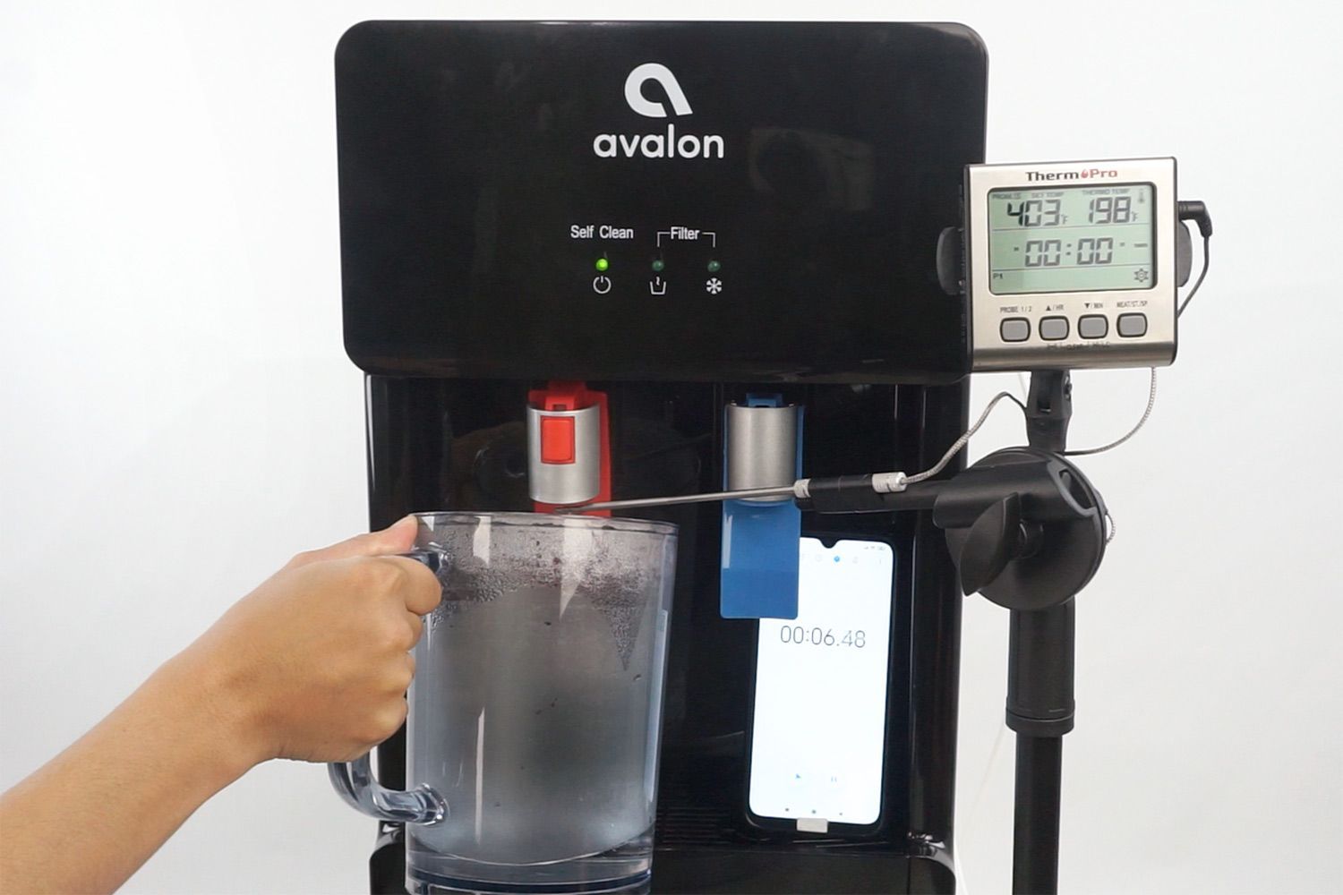 Water temperature being measured as hot water flows out the nozzle of a water cooler dispenser.