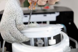 Demonstration of how to open the lid on the cold water tank of a water cooler dispenser.