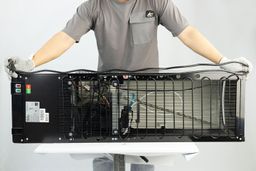 A man holding the electric cord of a water cooler dispenser double folded across the body in a horizontal position.