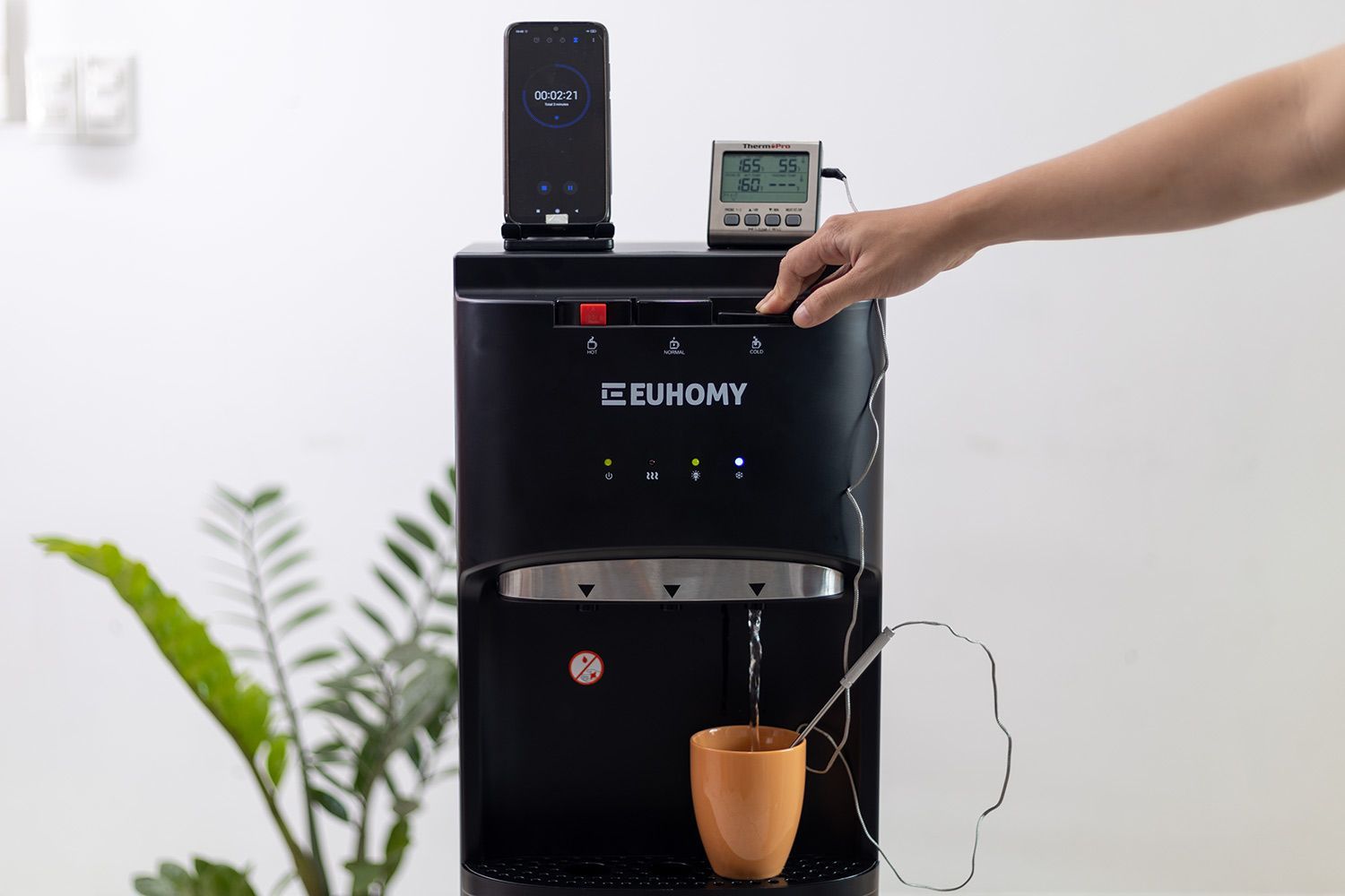 Water temperature being measured as cold water flows out the nozzle of a water cooler dispenser.