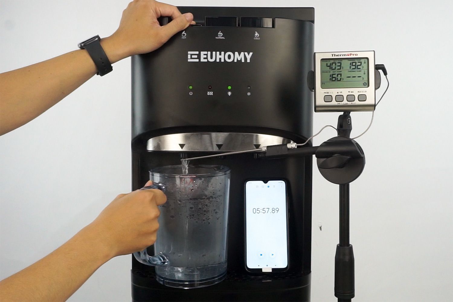 Water temperature being measured as hot water flows out the nozzle of a water cooler dispenser.