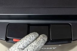 The middle button of a water cooler dispenser being held down showing the space in between.