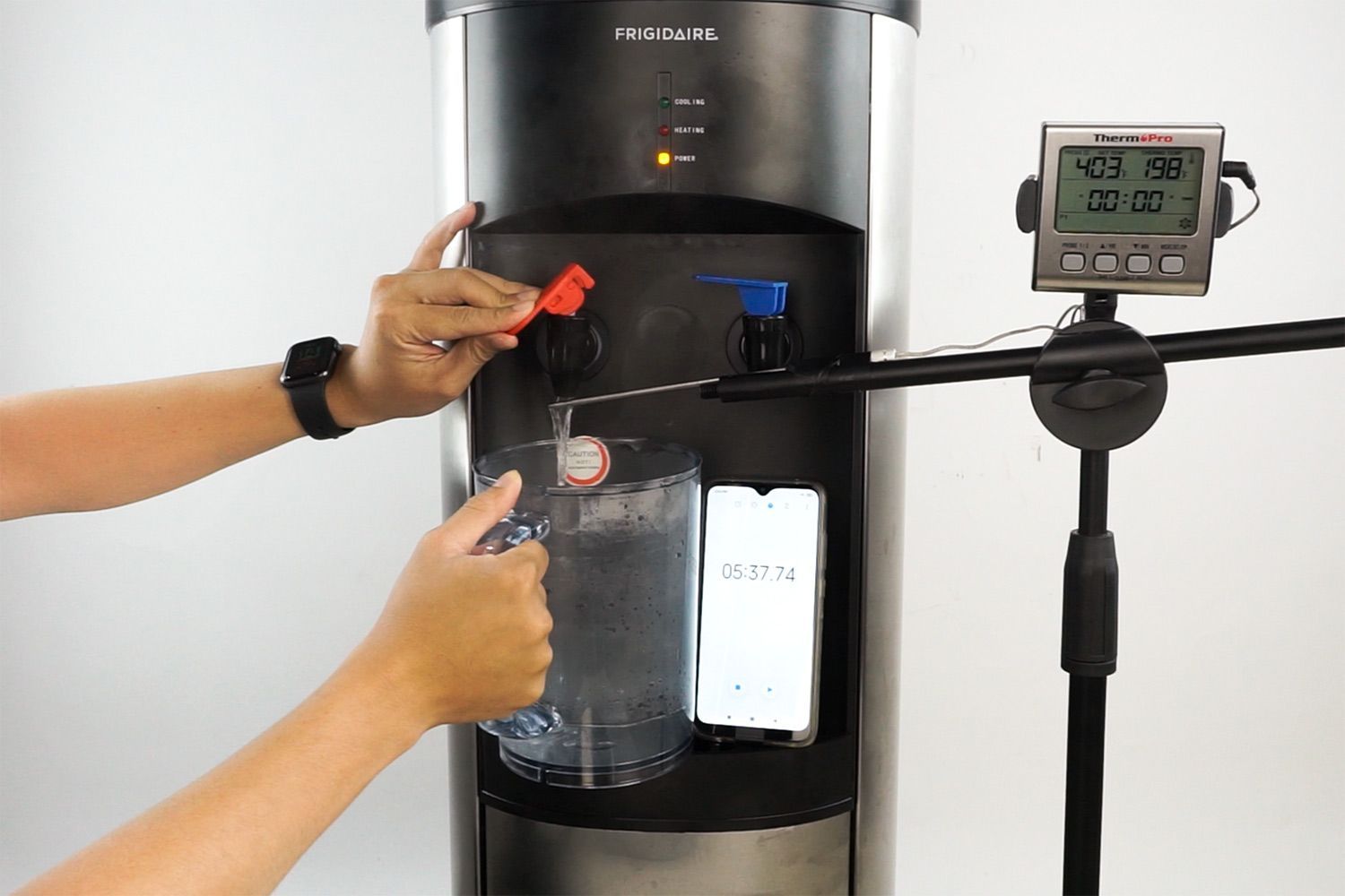 Water temperature being measured as hot water flows out the nozzle of a water cooler dispenser.