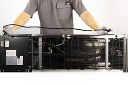 Man holding an electric cord double-folded across the horizontal rear view of the Frigidaire EFWC519 water cooler dispenser.