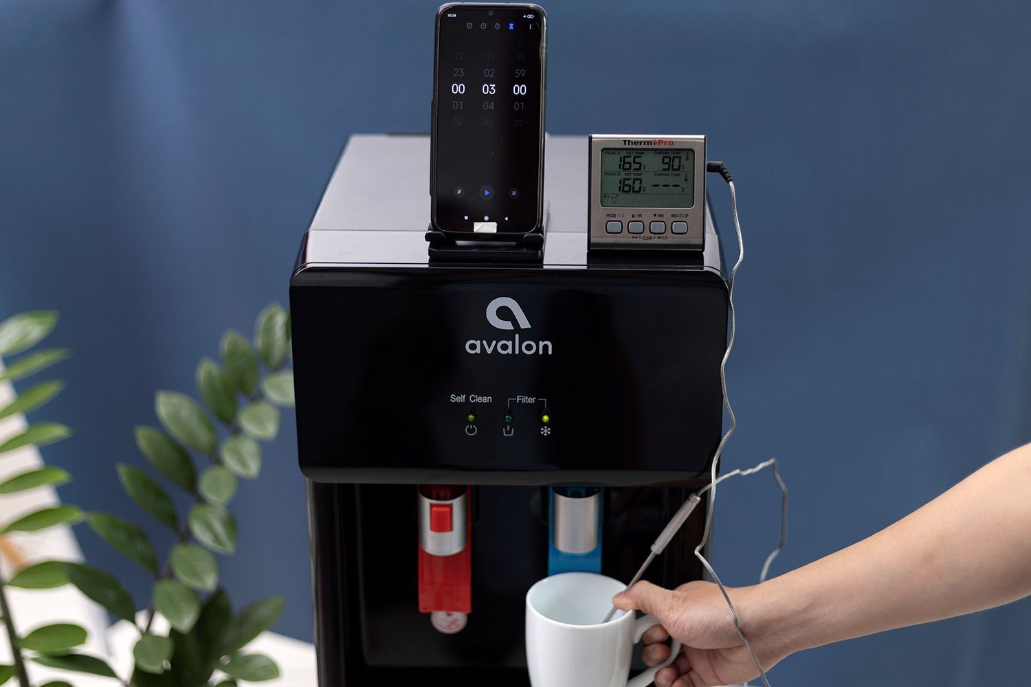 Water temperature being measured as cold water flows out the nozzle of a water cooler dispenser.