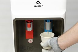 Cold water being dispensed from a water cooler dispenser with a one-hand lever operation.