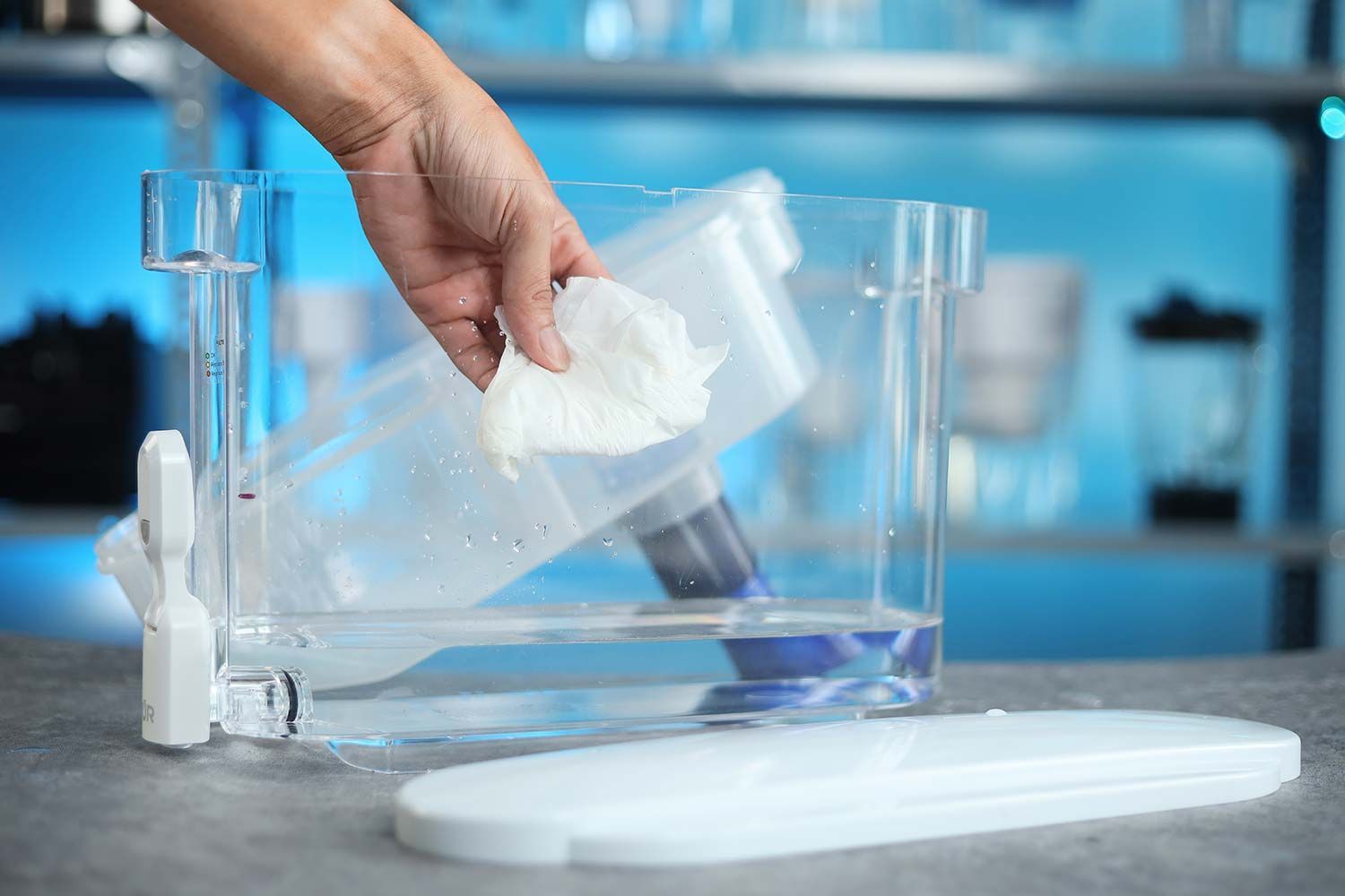 Hand cleaning the inside of the PUR plus dispenser with a tissue