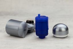 The blue, plastic-shelled filter cartridge of the PUR Plus PFM350V surrounded by detached plastic parts of the filter.