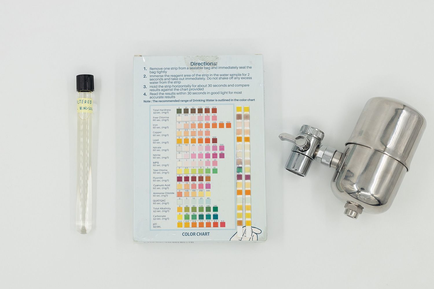 Center is the color pad with used test strips. To its right is the Wingsol WS-FM001 filter. To its left is a vial of water.