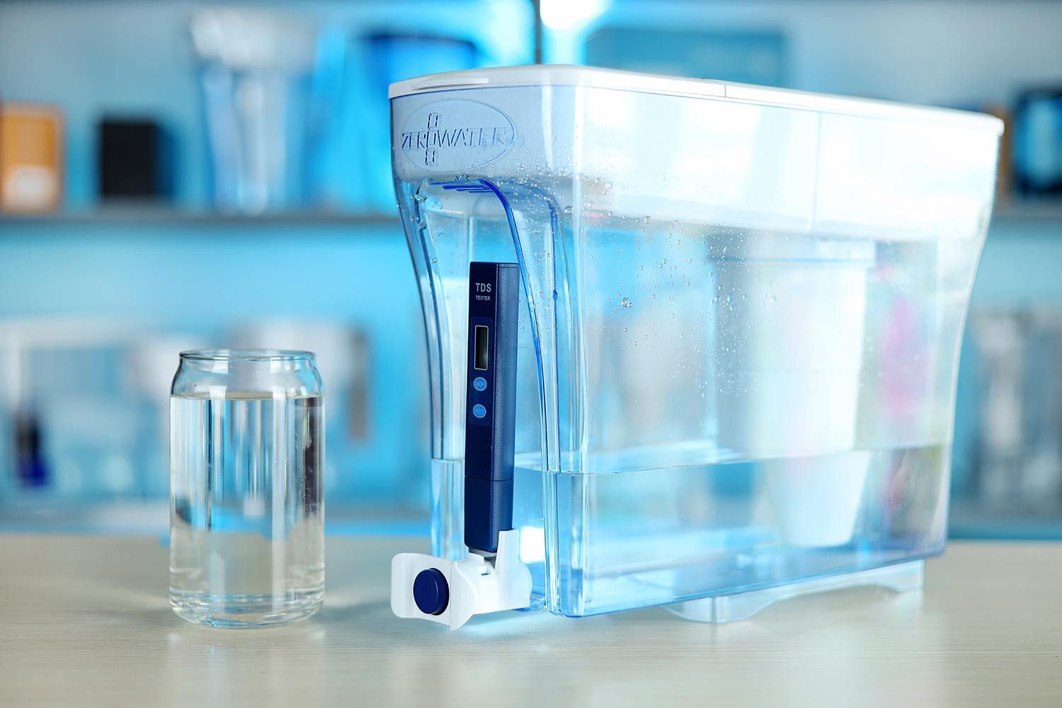 The ZeroWater 23 cup water filter dispenser next to a water glass on a table